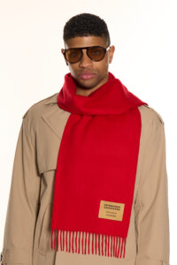 A folded red tartan cashmere scarf in a luxury signature gift box.