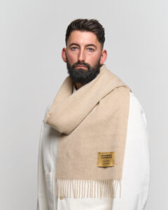A folded dark grey cashmere scarf in a luxury signature box.