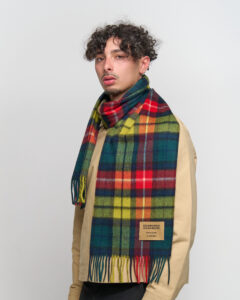Classic tartan and solid scarves displayed to show heritage craftsmanship